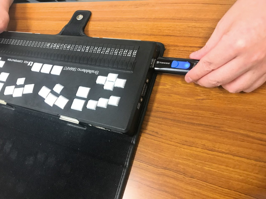 USBメモリをブレイルメモスマートに接続されているときの写真。先生が作ったレジュメのWordデータを、USBメモリに入れて受け取っていました。